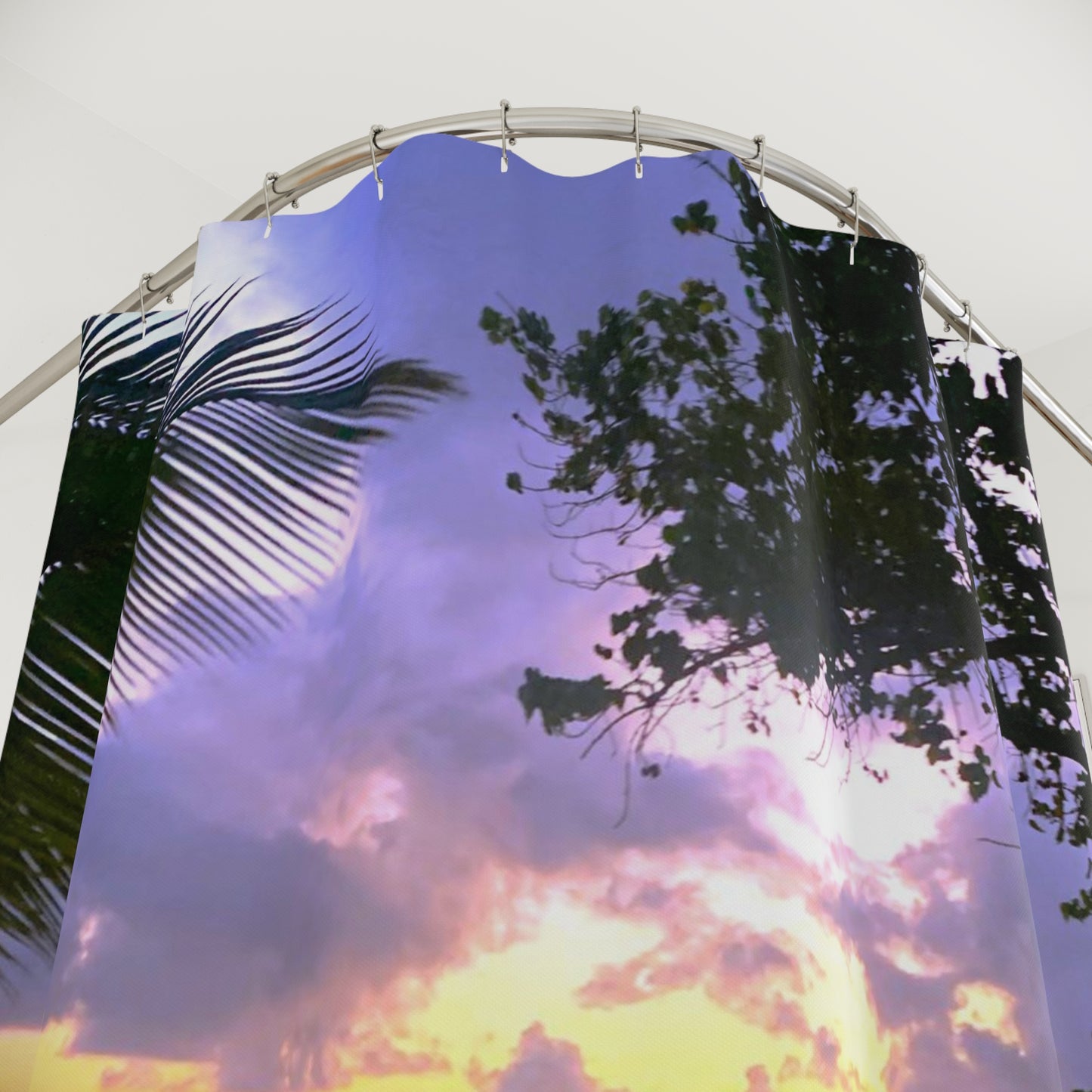 Close-up of a tropical sunset shower curtain with silhouetted palm fronds and a golden-purple sky.