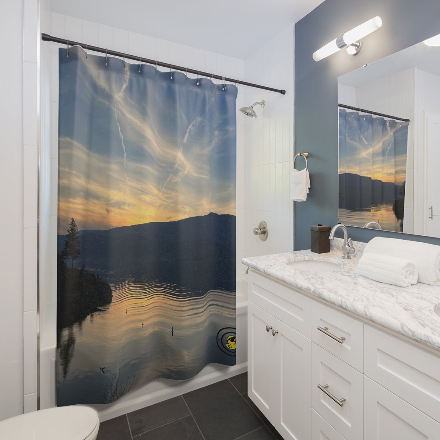 Bathroom with a lake sunset shower curtain, white vanity, marble countertop, and large wall mirror.