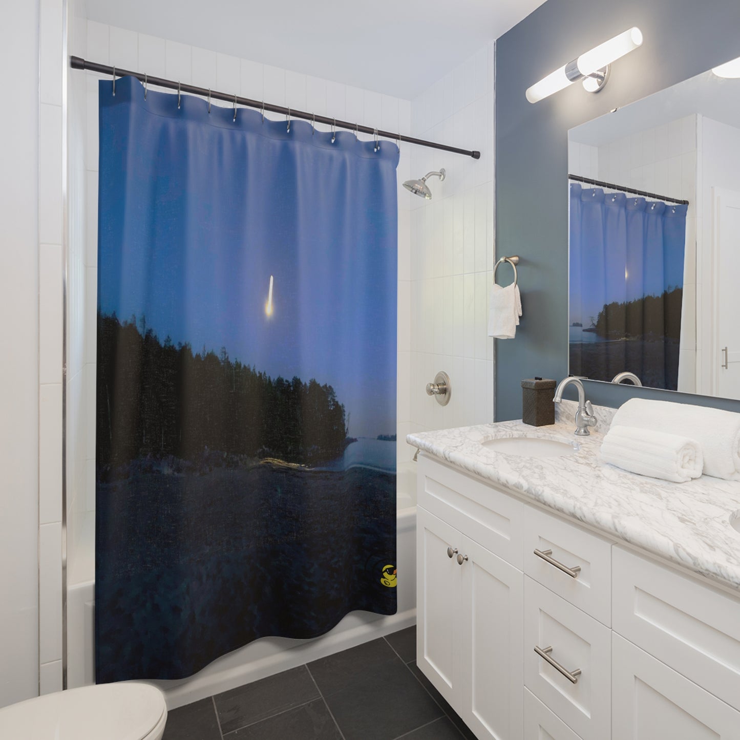 Contemporary bathroom with the “Beach Shooting Star” shower curtain featuring a glowing star streaking across a night sky above a forested coastline.
