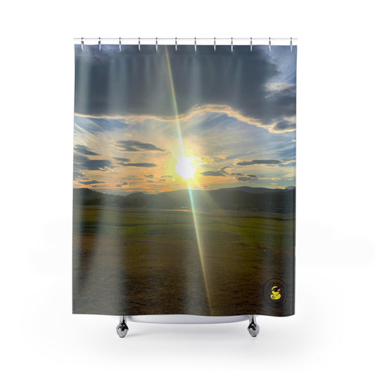 Shower curtain featuring a vivid meadow sunset with golden skies and layered clouds. Adding warmth to a modern bathroom.
