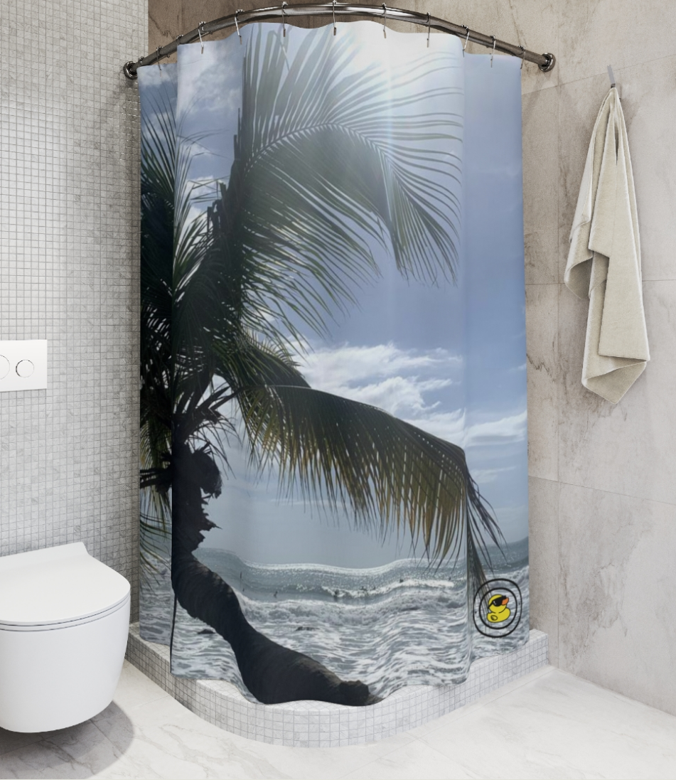 Palm tree shower curtain in a modern bathroom. Displaying a sunlit tropical beach with crashing waves and clear skies.