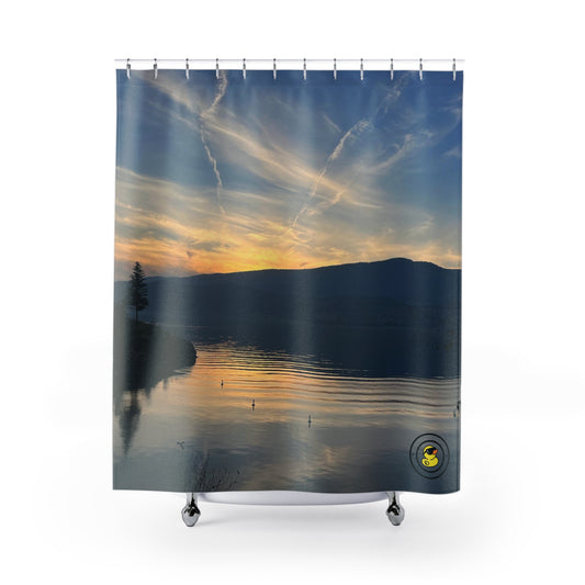 Shower curtain with a peaceful lake at sunset, glowing sky, streaked clouds, and soft ripples on calm water.