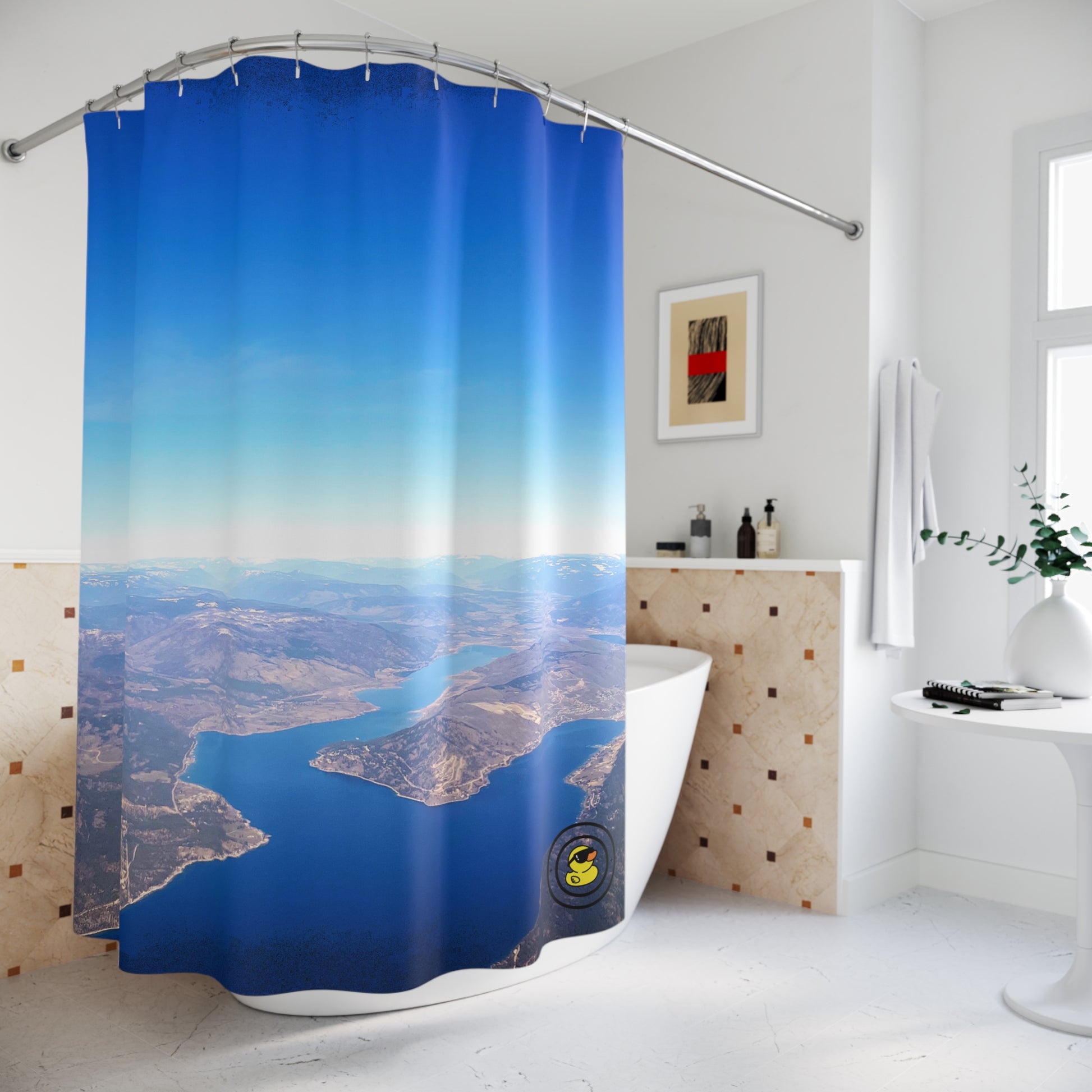 Scenic aerial landscape shower curtain in modern bathroom with curved rod and wall-mounted decor.