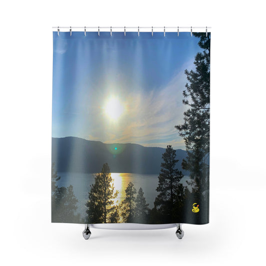 Shower curtain with a glowing sun above a calm lake, framed by silhouetted trees and distant mountain peaks.