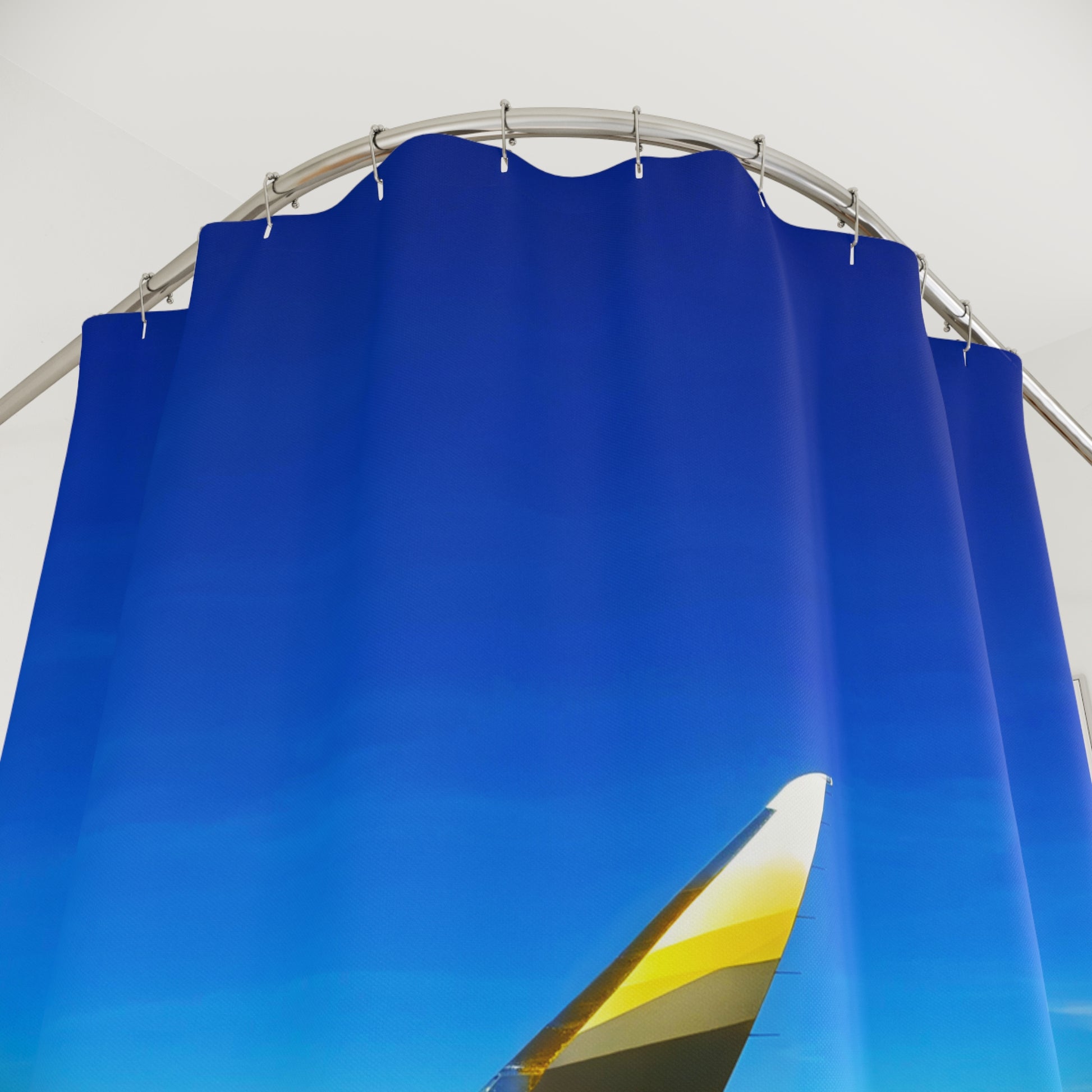 Shower curtain with airplane wingtip against vivid blue sky. Captured from an aerial perspective in flight.